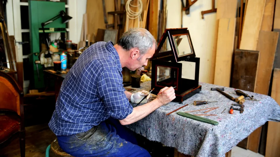 Artisan travaillant sur un objet en bois dans l’atelier